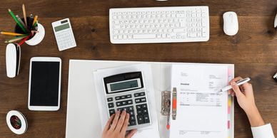 Professional reviewing financial documents and calculator for logistics cost analysis