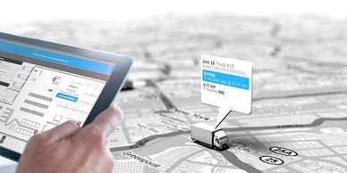 Hand holding a tablet displaying a real-time logistics tracking dashboard