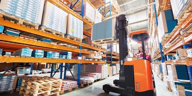 Forklift operator in a modern warehouse with organized shelving and inventory